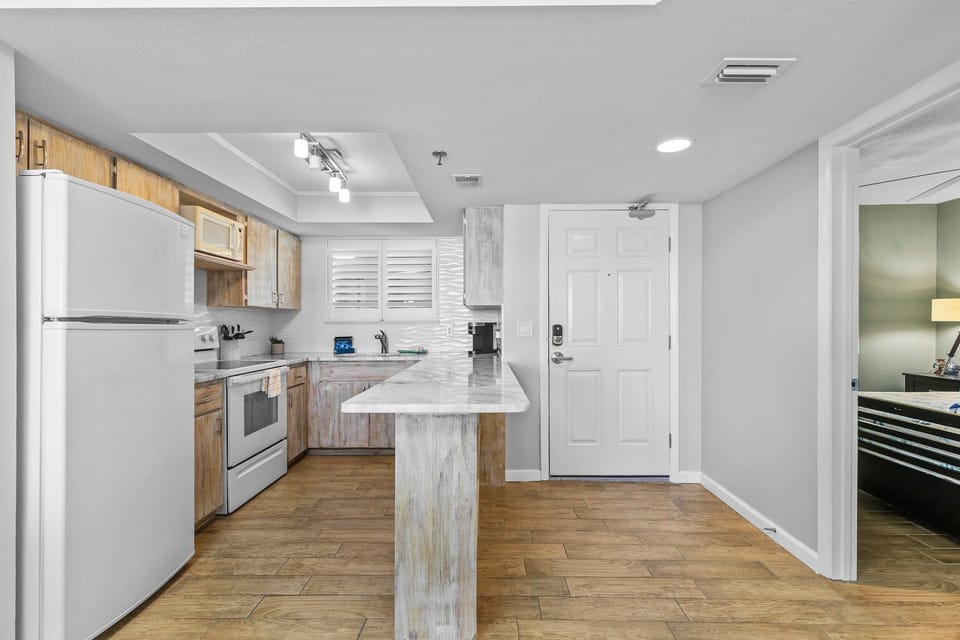 Fully equipped kitchen with rustic cabinets, marble-style countertops, and modern appliances for all your cooking needs.