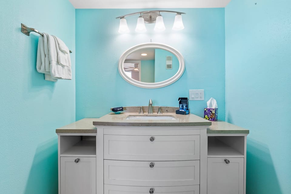 Refresh in this sleek bathroom featuring a spacious vanity, bright lighting, and a relaxing coastal design.