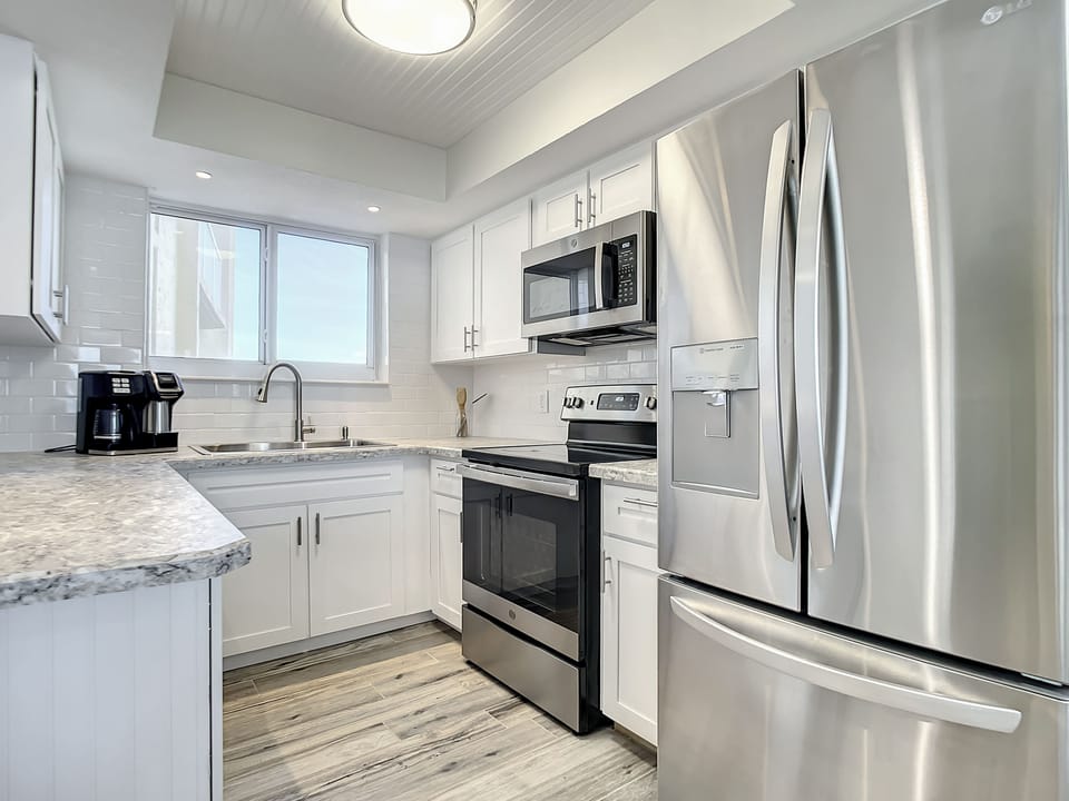 Bright, fully equipped kitchen with stainless steel finishes and elegant cabinetry for a stylish cooking experience.