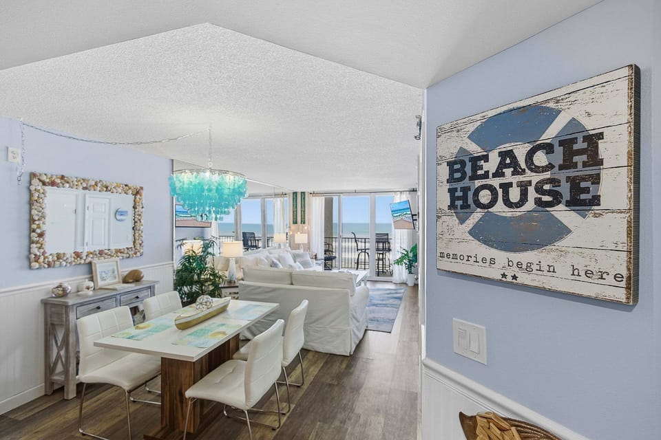 Welcoming entry opens to a bright dining and living area with coastal décor and ocean views. Perfect for your beach stay, enjoy an inviting space that leads straight to relaxing seaside comfort.