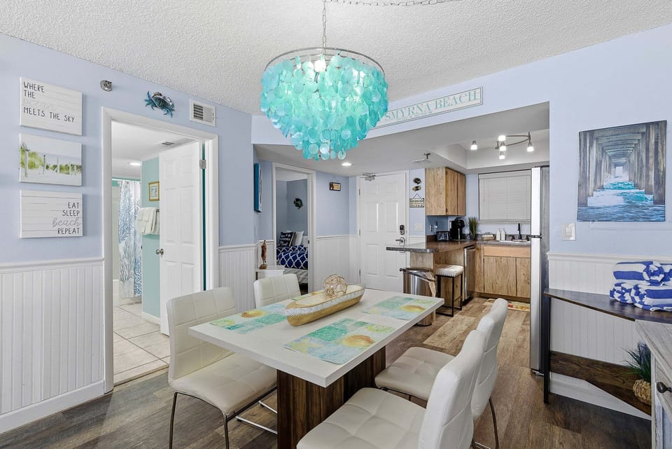 Inviting dining area with coastal décor, seating for family meals, and easy access to the kitchen. Perfect for your beach stay, gather and dine comfortably after a relaxing day by the ocean.