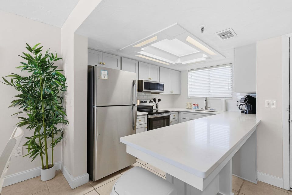 This beach stay features a bright, fully equipped kitchen with modern appliances and a spacious breakfast bar. Perfect for preparing meals and snacks before or after enjoying a relaxing day at the beach.