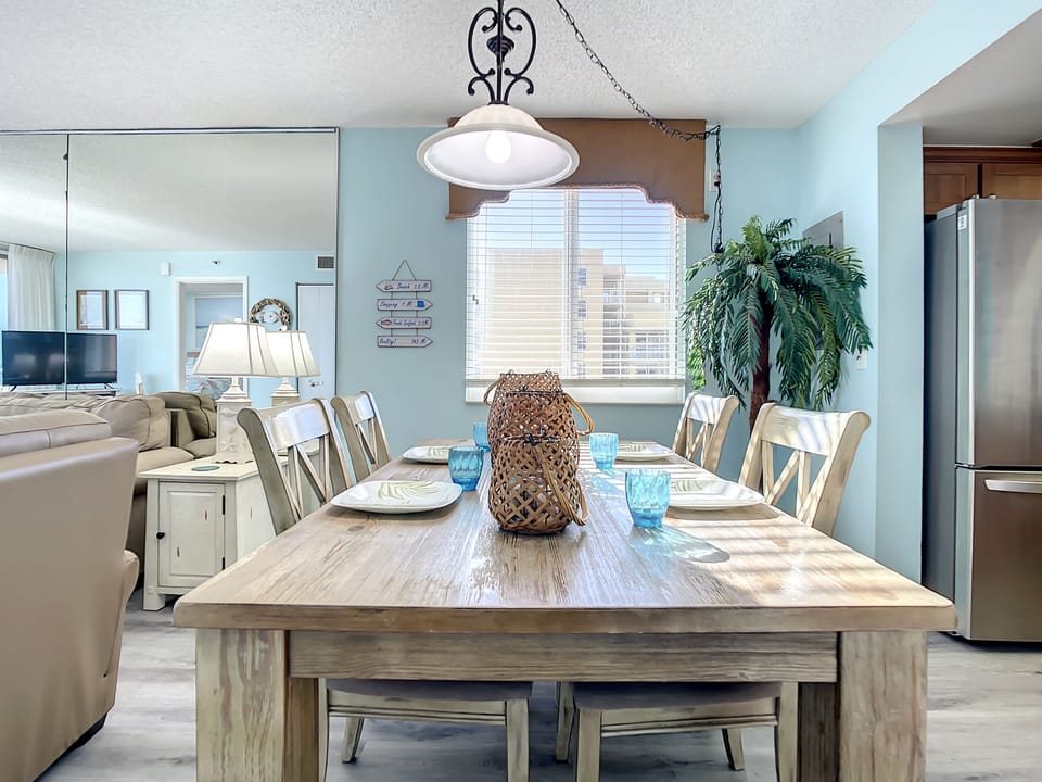 Spacious dining area with rustic wooden table, ocean views, and ample seating, ideal for family gatherings by the sea.