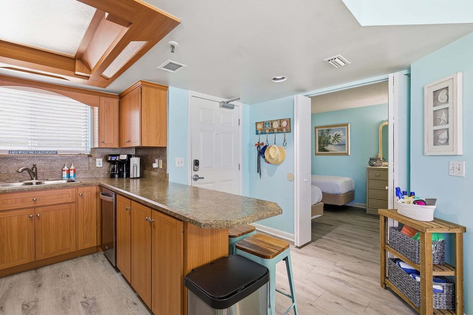 Fully equipped kitchen with granite countertops, breakfast bar seating, and open flow to living areas. Ideal for your beach stay, offering convenience, coastal charm, and everything needed for easy vacation dining.