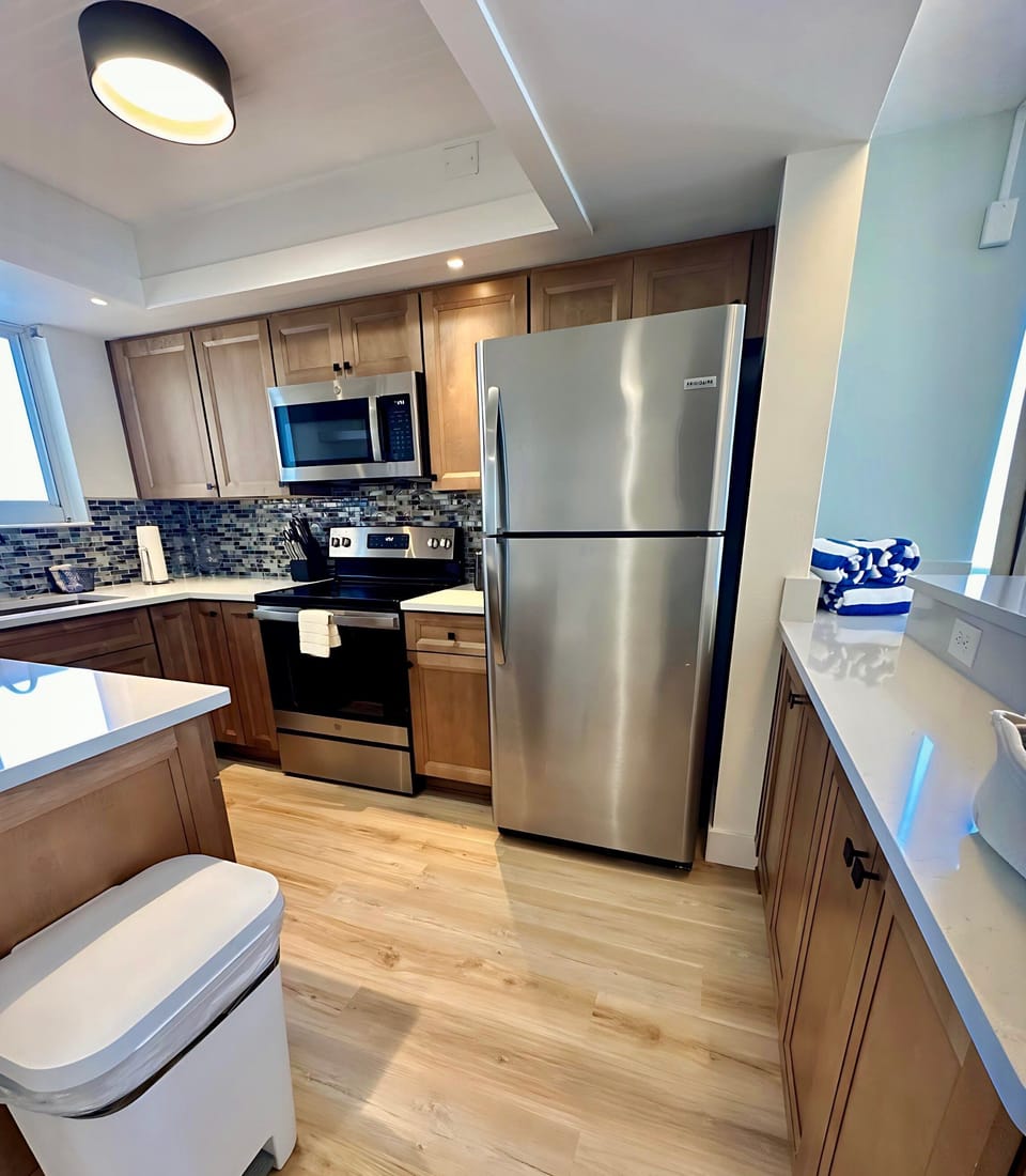 Enjoy the perfect blend of style and function in this fully equipped kitchen, featuring stainless steel appliances, sleek cabinetry, and a beautiful backsplash—ideal for preparing meals with ocean views.