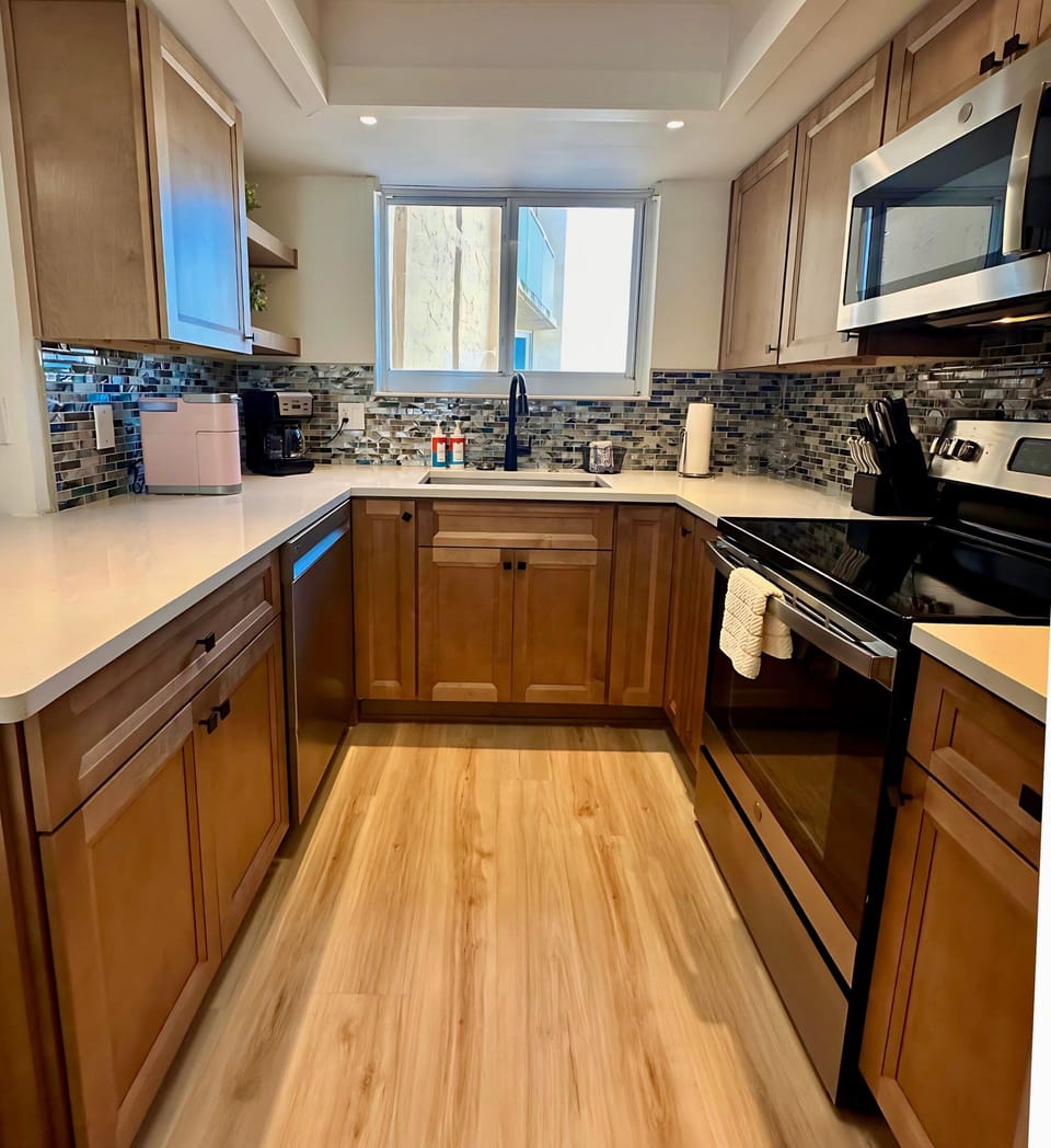 This well-appointed kitchen features warm cabinetry, modern appliances, and a mosaic backsplash. Ample counter space and natural light make it ideal for whipping up delicious meals in coastal comfort.