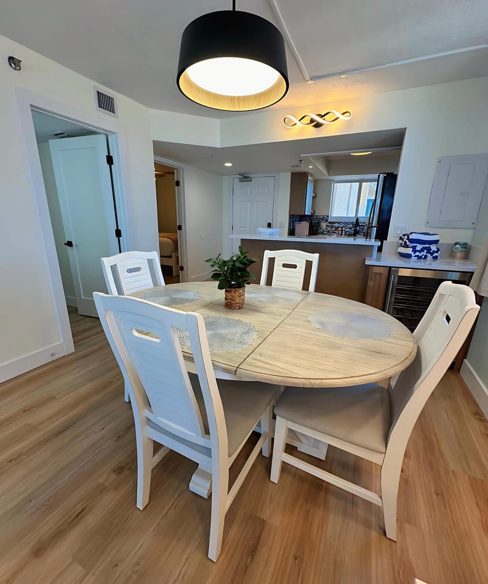 This welcoming dining space blends coastal charm with comfort. Whether enjoying meals or casual chats, it's the perfect spot to connect—conveniently located near the kitchen and entry for easy flow.
