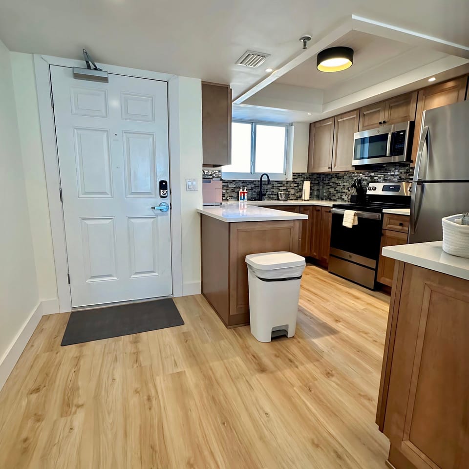 Step into a bright, modern retreat where the entry flows into a sleek kitchen. Thoughtfully designed for comfort and convenience—your perfect home base for a beachside getaway.