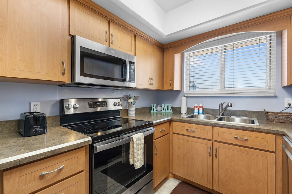 Prepare beachside meals with ease in this fully equipped kitchen featuring modern appliances, ample counter space, and coastal touches—perfect for your oceanfront stay.