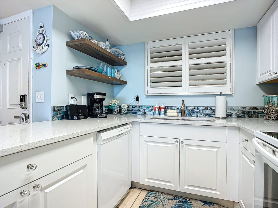 Functional kitchen with open shelving, nautical accents, and a calming blue backsplash for a coastal vibe.