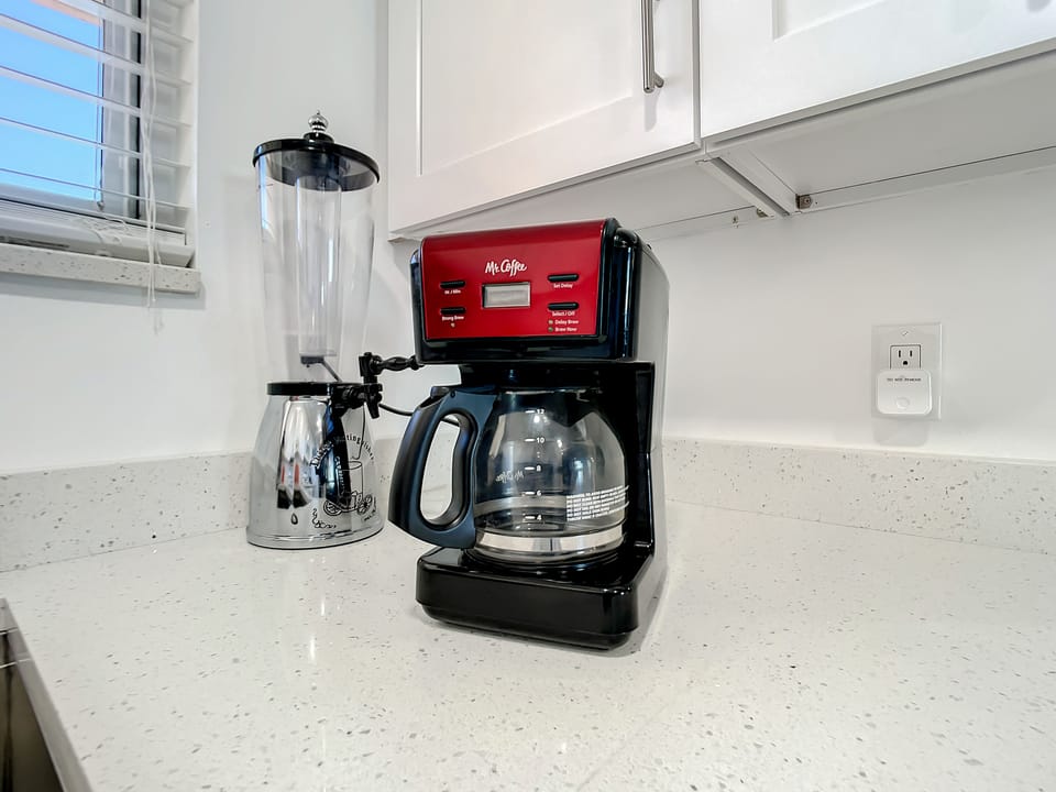 Start your day right with a coffee maker and blender, conveniently located in a modern kitchen.
