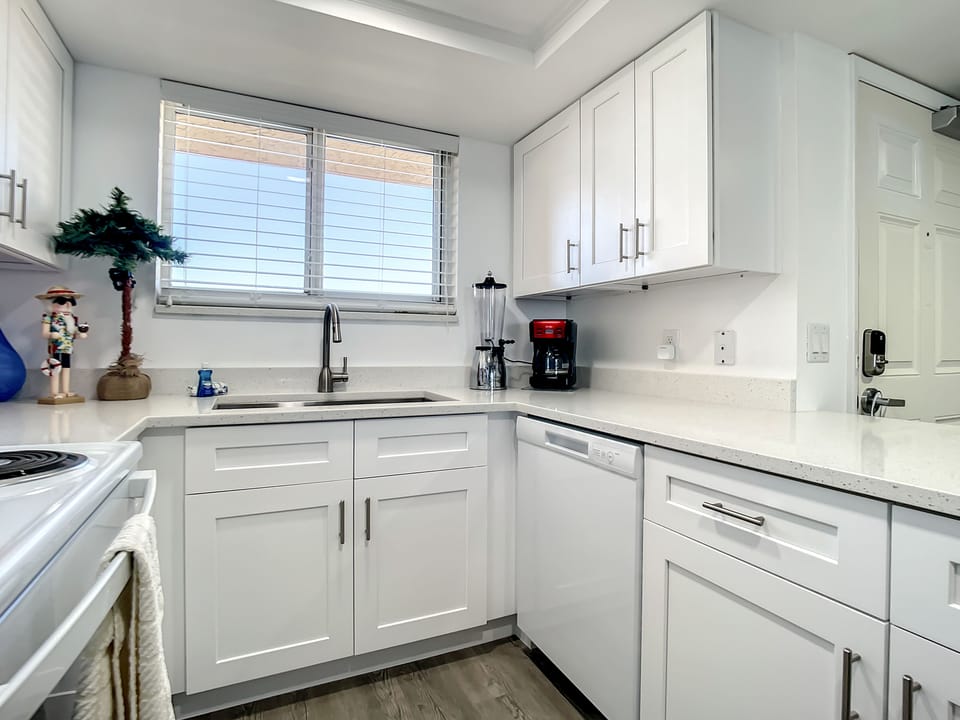 Bright white cabinetry, sleek countertops, and modern appliances make this kitchen perfect for any culinary adventure.