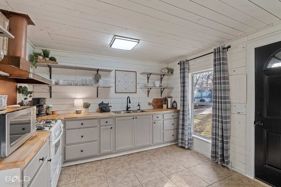 The charming kitchen has original shiplap walls & ceiling.