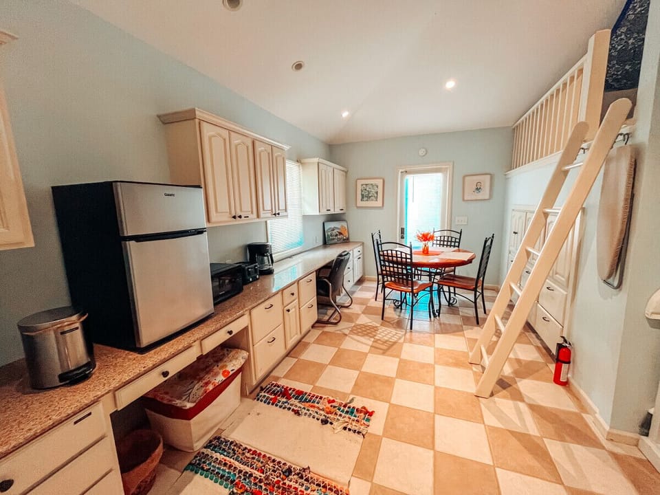 Kitchenette equipped with: mini fridge, toaster, microwave, drip coffee machine, plates, cups, bowls, mugs, silverware, and Brita