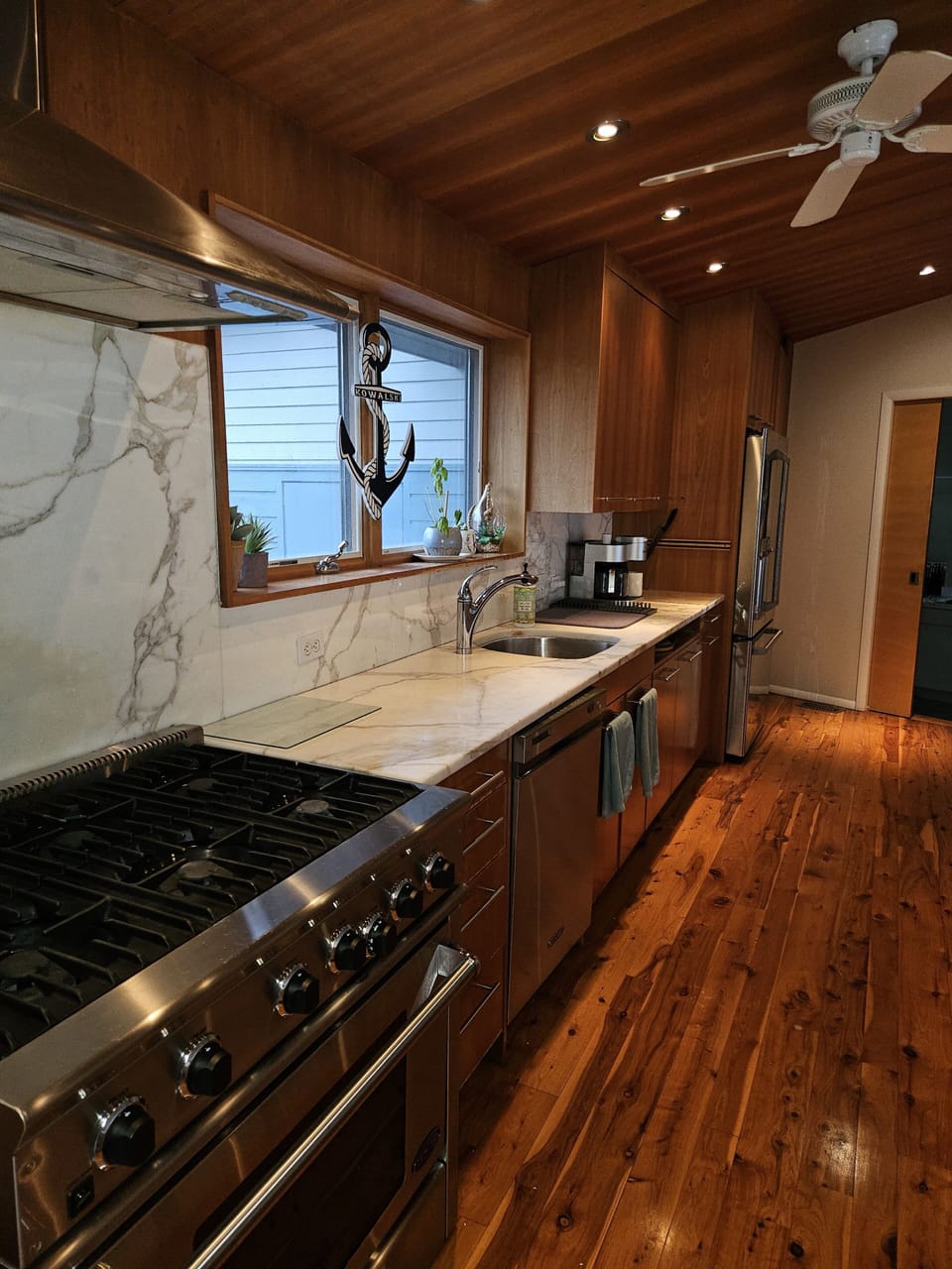 Kitchen with gas range, marble counter tops and GE Café fridge