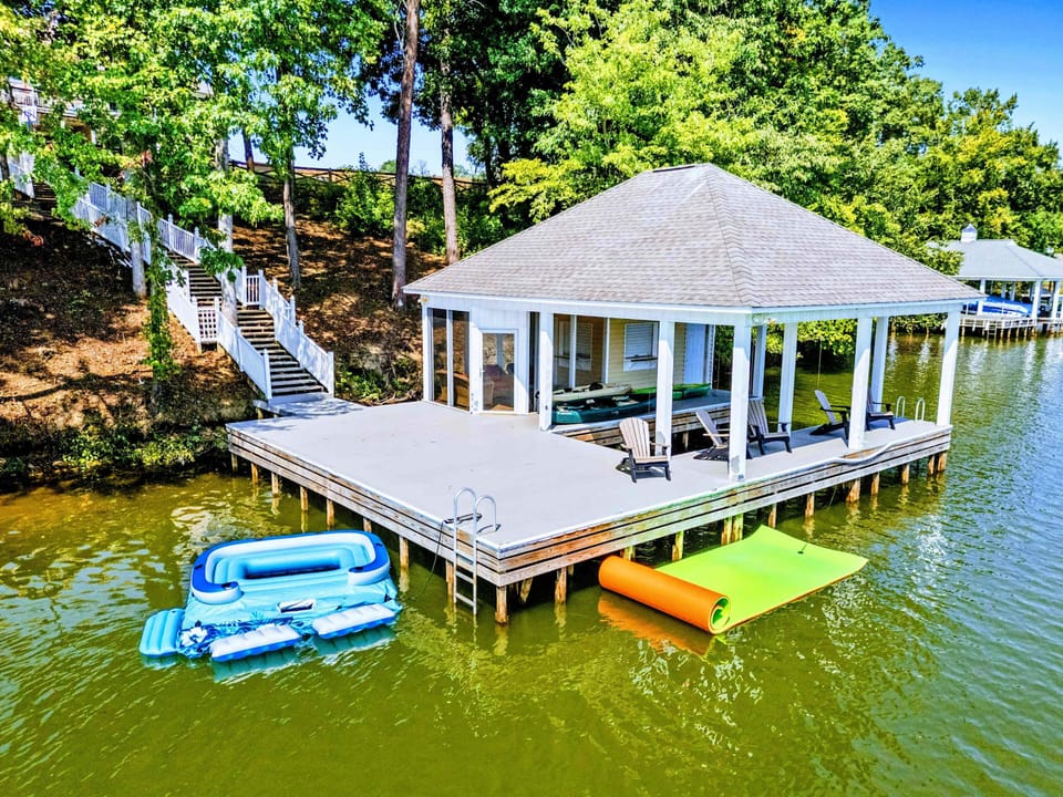 Dock - Aerial view of the covered boathouse, swim platform, and colorful floats ready for the water.