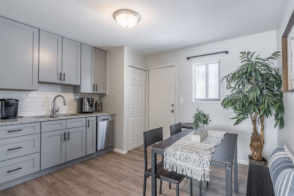 Modern dining area with high-top table seating for four, perfect for meals, work, or game nights. Open layout with easy access to the kitchen and living space…bright, airy, and designed for everyday comfort.