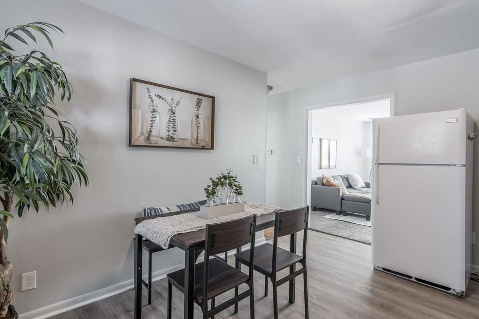 Modern dining area with high-top table seating for four, perfect for meals, work, or game nights. Open layout with easy access to the kitchen and living space…bright, airy, and designed for everyday comfort.
