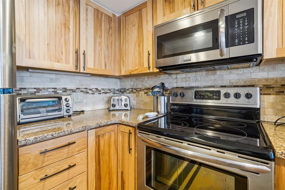 Stainless steel appliances and natural wood finishes create a clean, inviting space for cooking and gathering.