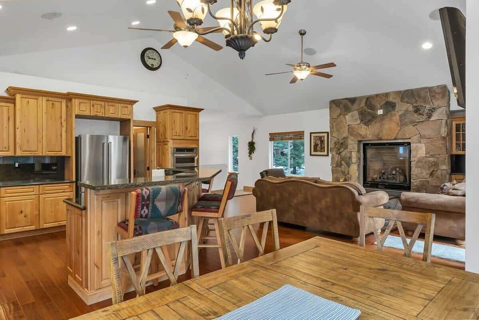The view from the dining table towards the living room and the beautiful stone accent wall that surrounds the gas fireplace.