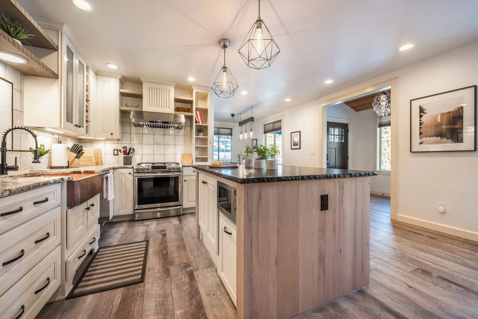 The fully equipped kitchen features stainless steel appliances, a large center island, and open shelving—perfect for effortless meals and gathering with ease.







