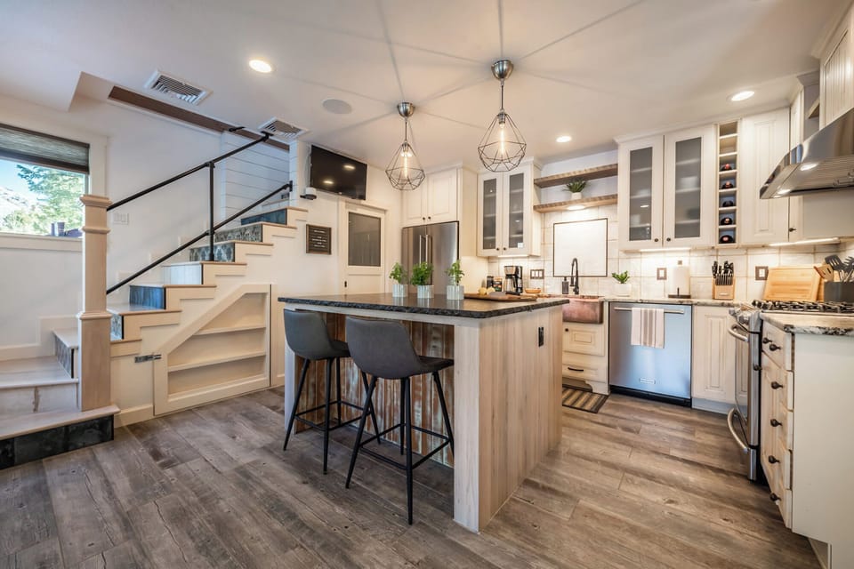 Bright and modern, the fully stocked kitchen features a spacious island, stylish lighting, and everything you need for home-cooked meals and gatherings.