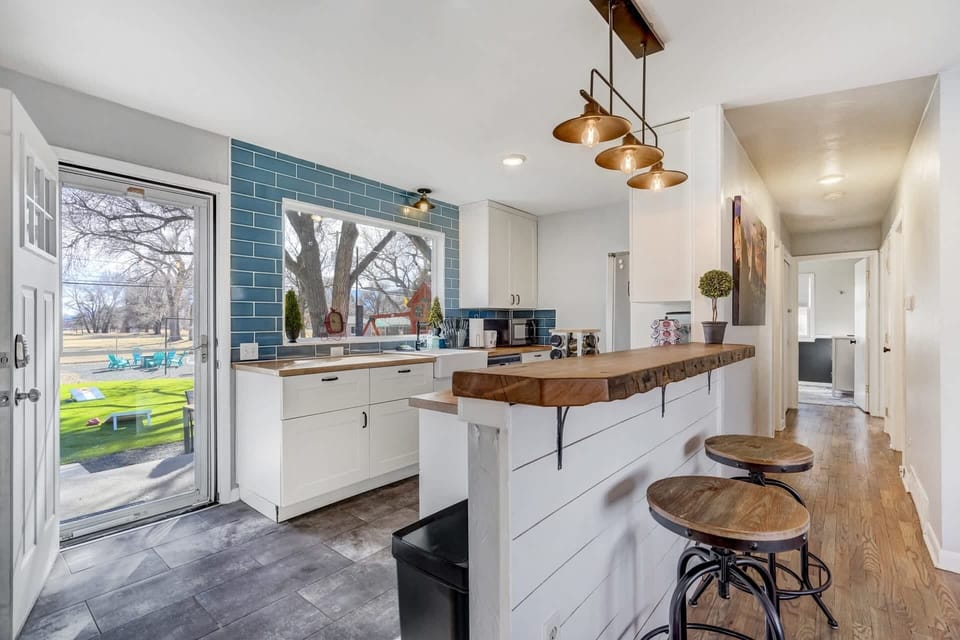 Dish duty just got better with this kitchen setup – scrub away while enjoying a picturesque view of the backyard through the large window.