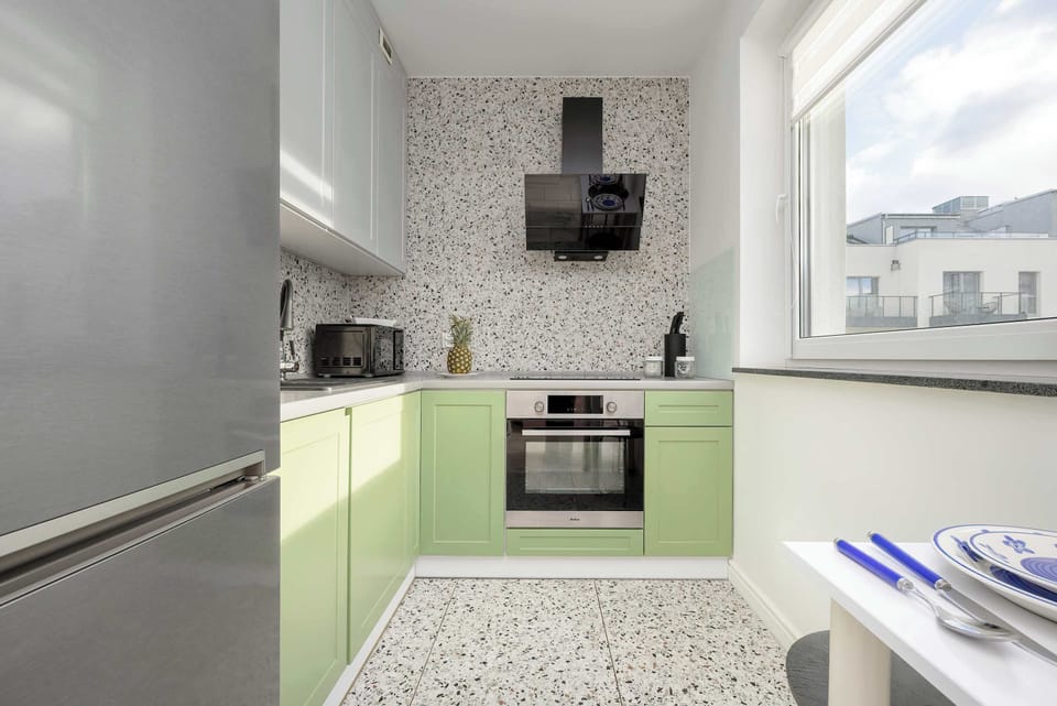 A stylish kitchen corner with fresh flowers, glossy finishes, and a bright atmosphere.
