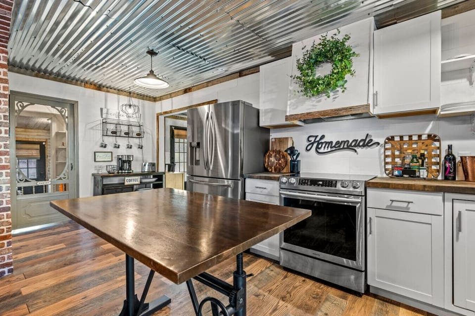 The kitchen is complete with a stand-alone island table, pots/pans, dishes, silverware, bakeware, and more.