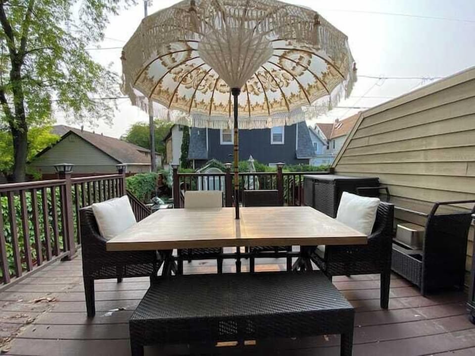 Inviting outdoor deck with comfortable dining seating and a large umbrella