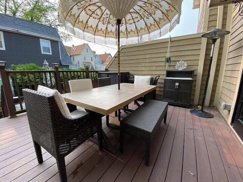 Inviting outdoor deck with comfortable dining seating and a large umbrella
