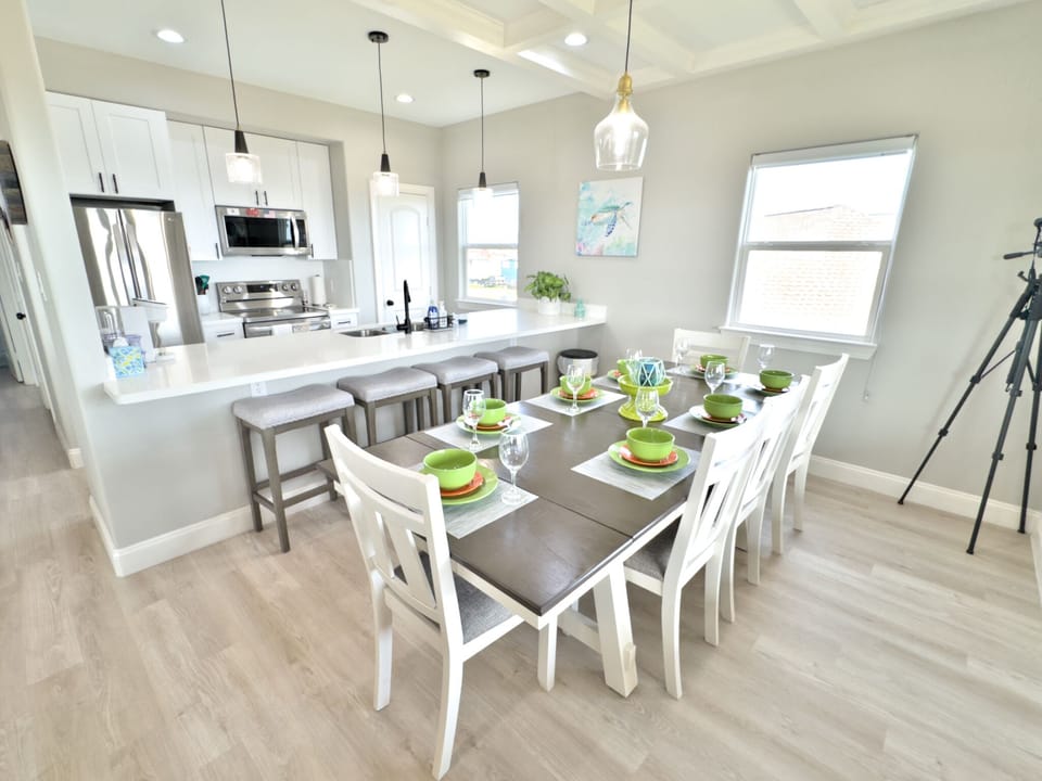 Well-lit dining area with table for 8 plus 4 at the kitchen island