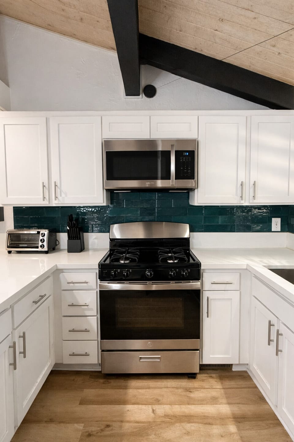 Fully equipped kitchen with stainless steel appliances, including microwave, oven, dishwasher, and refrigerator — stocked with everything you need to cook at home.