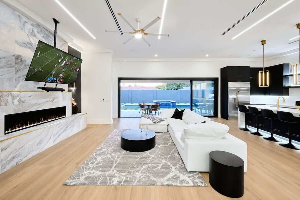 Grand designer furnished open-concept living space featuring an electric fireplace, and a Smart TV for entertainment.