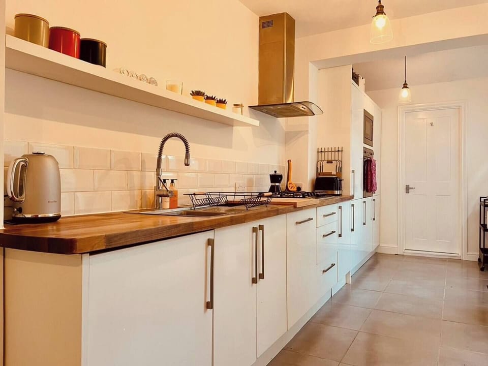 Fully equipped galley kitchen leading to downstairs bathroom and garden
