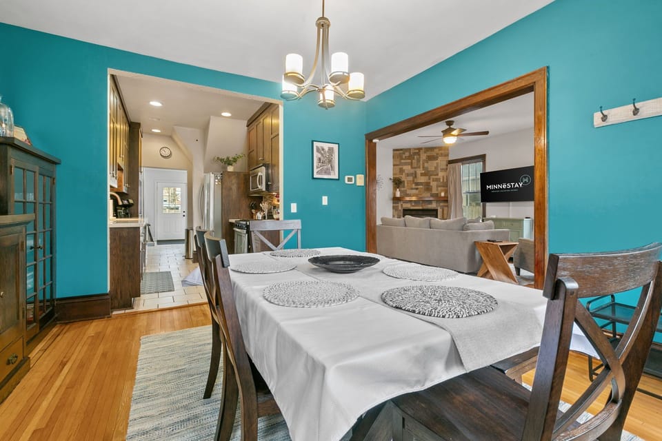 Gather around your spacious dining table, where vibrant turquoise walls create a cheerful backdrop for memorable meals together.