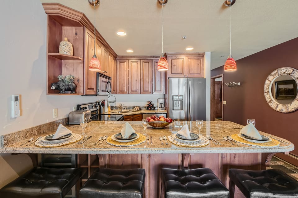 Enjoy a fully equipped kitchen with stainless-steel appliances, granite counters, and a spacious breakfast bar set for four. Perfect for cooking après-ski meals and gathering with friends during your Park City stay.