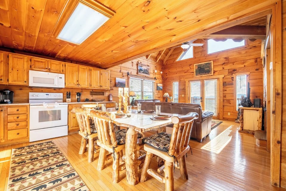 Step into this sun-drenched open-concept cabin where rustic log dining meets modern comfort. Natural light pours, illuminating warm wood throughout your cozy mountain retreat.