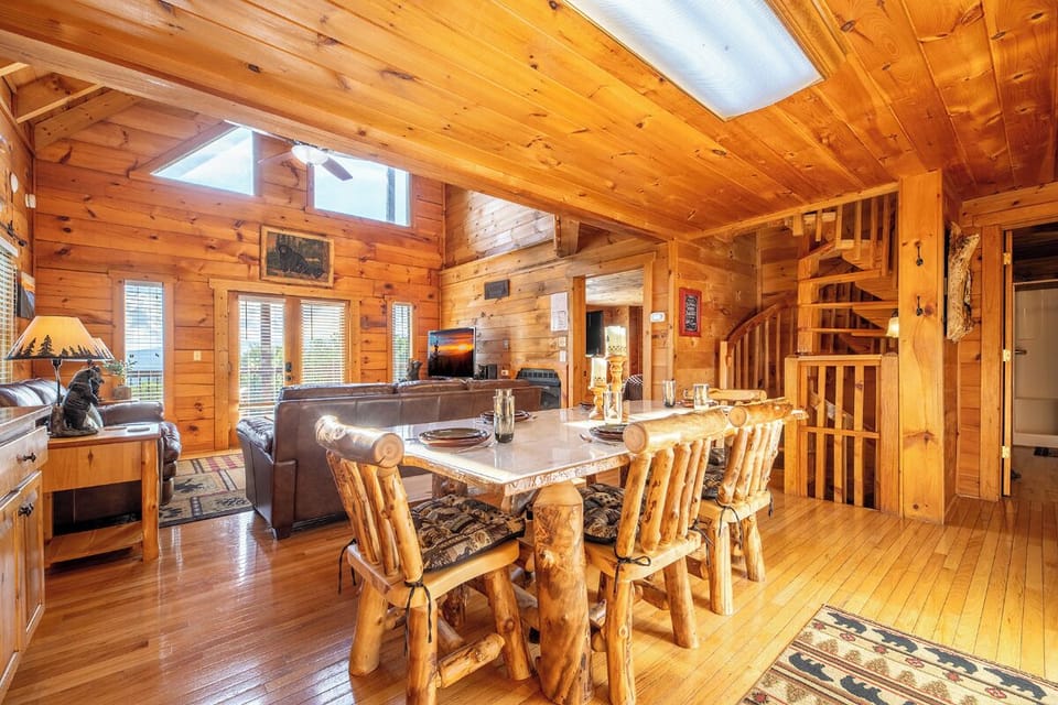 Sunlight illuminates warm wood walls and rustic log furnishings—your cozy mountain retreat where every meal feels like a celebration.