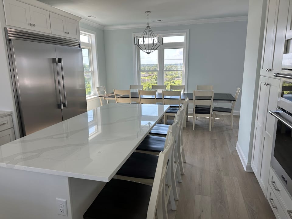 Kitchen bar with four stools, dining room table that can accommodate 14