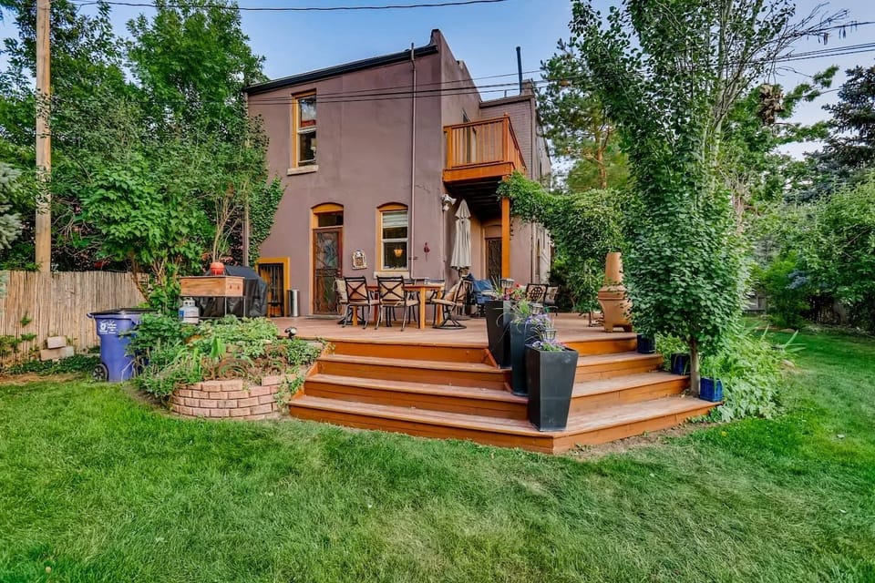Lush backyard with large deck, seating, and grass space