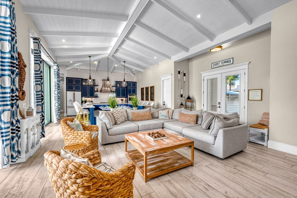 Airy living area with vaulted ceilings and sliding doors that open straight to the poolside.
