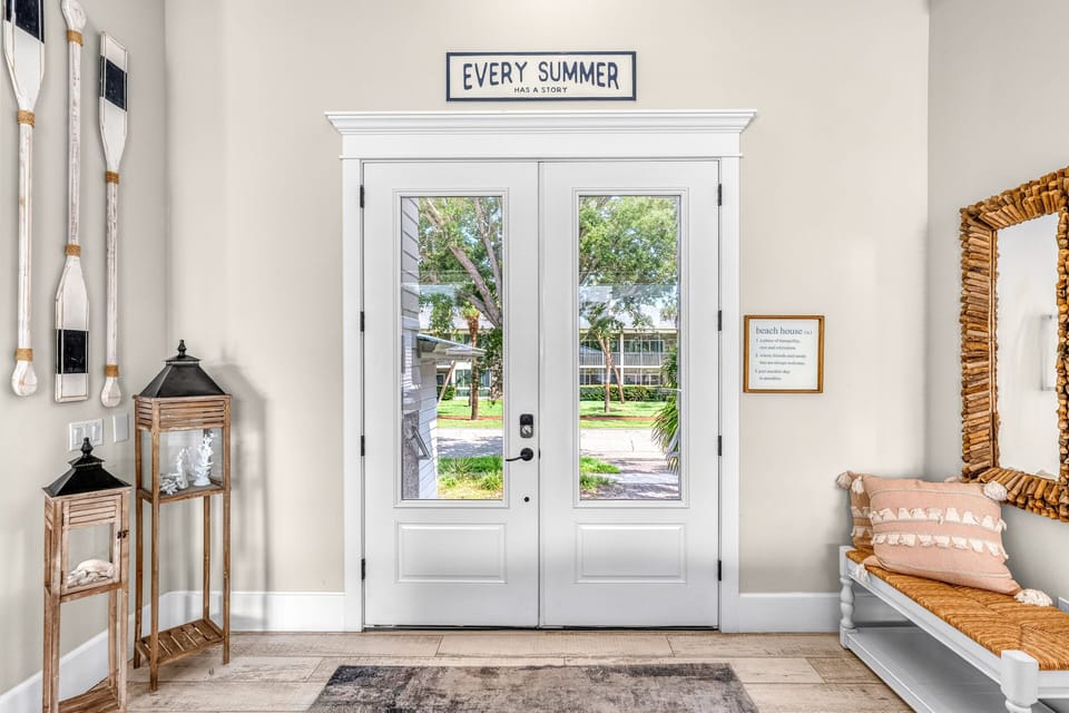 Step inside to a bright, welcoming foyer where coastal décor and soaring ceilings instantly put you in vacation mode.