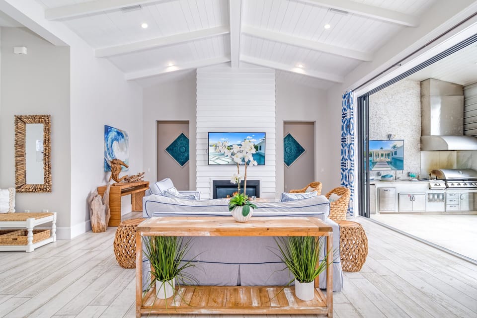 Airy living area with vaulted ceilings and sliding doors that open straight to the poolside.