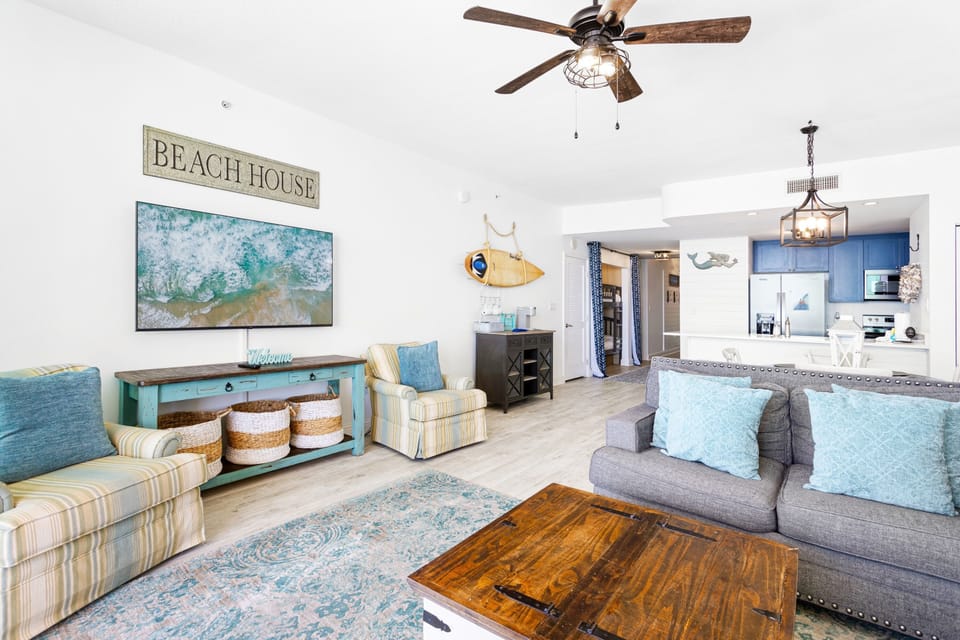 Relax in your coastal-themed living space where ocean blues meet comfortable furnishings, complete with modern kitchen and charming beach house touches.