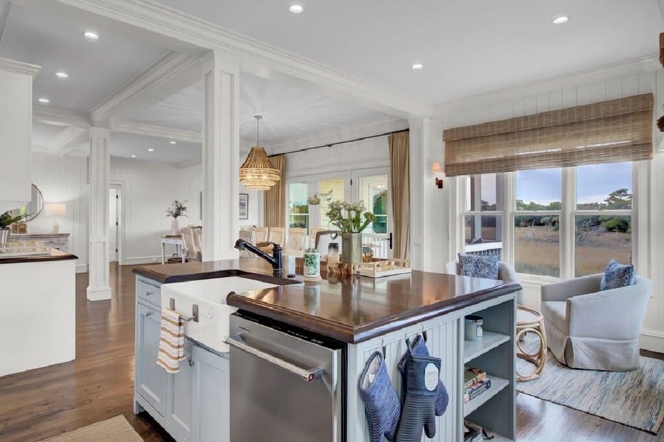 - Stunning chef’s kitchen with a rich wood island and farmhouse sink centerpiece - Open layout connects effortlessly to dining and living areas for easy entertaining - Thoughtful touches and coastal charm make this kitchen both stylish and functional
