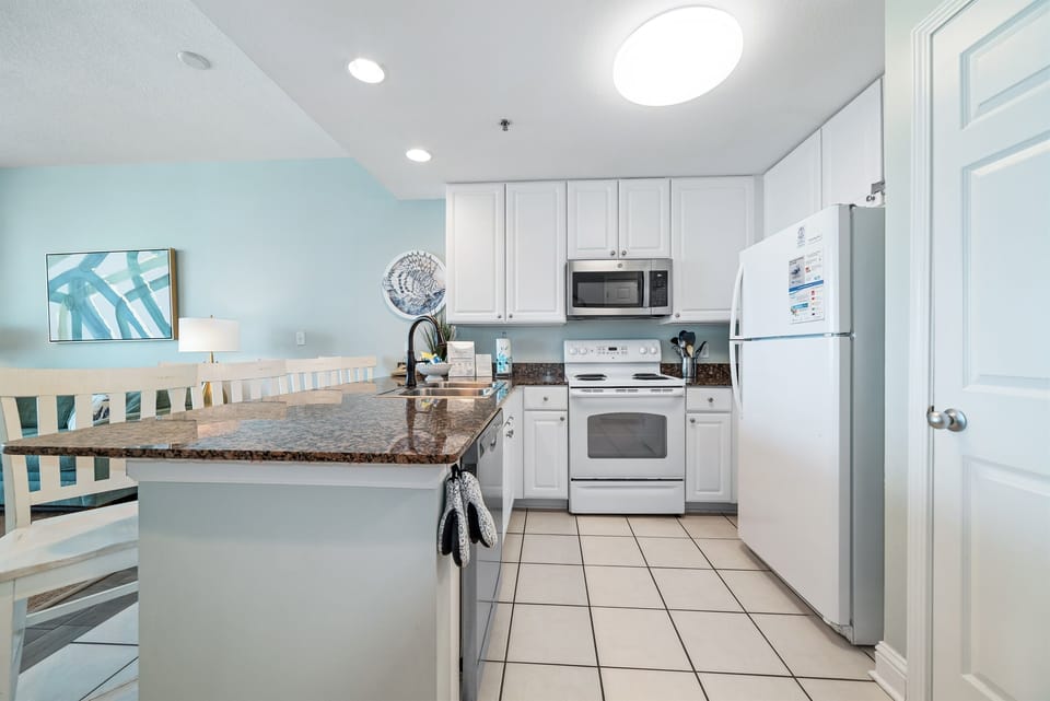 This fully functional kitchen boasts stainless steel appliances, sleek countertops, and ample cabinet storage, ideal for everyday cooking and entertaining.