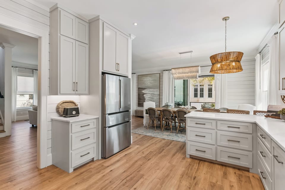 Your dream kitchen awaits with gleaming white cabinets, modern appliances, and a warm dining space perfect for memorable meals together.