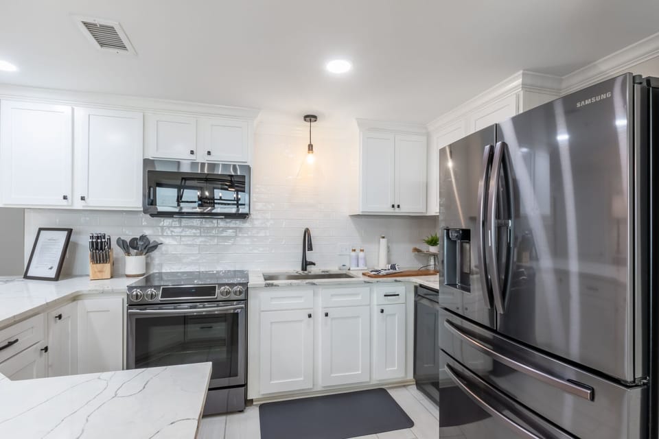 Cook and gather in this elegant kitchen with upgraded modern appliances, stylish lighting, and spacious marbled countertops