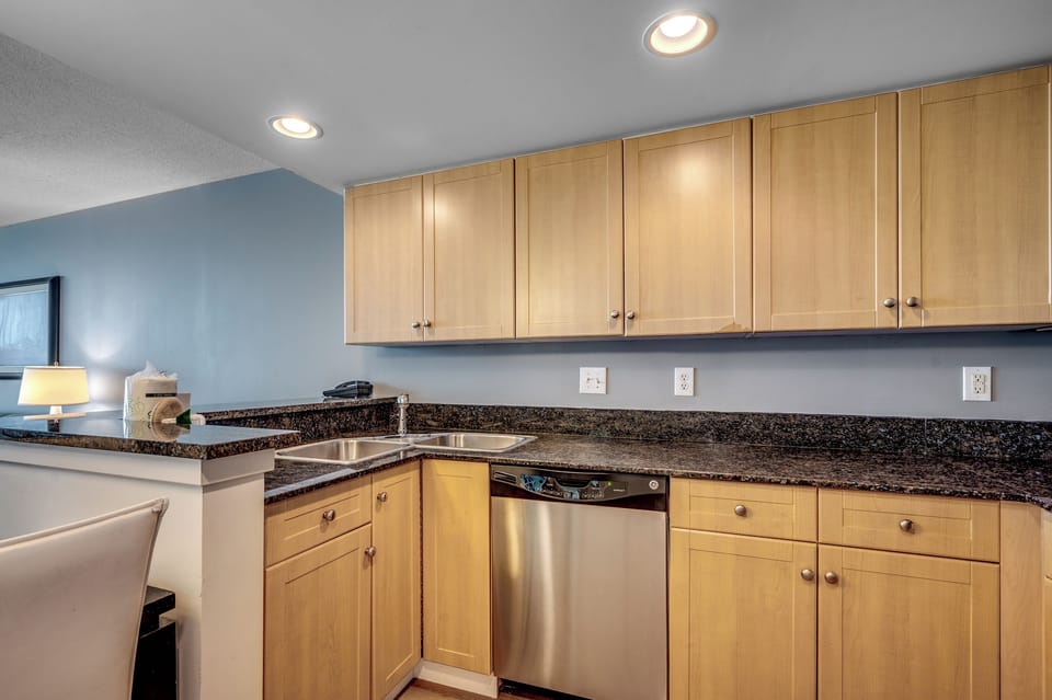 Modern kitchen with wood cabinets, granite counters, and stainless appliances